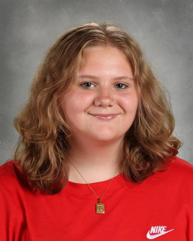 Portrait of Braylee Worden smiling in front of studio lighting