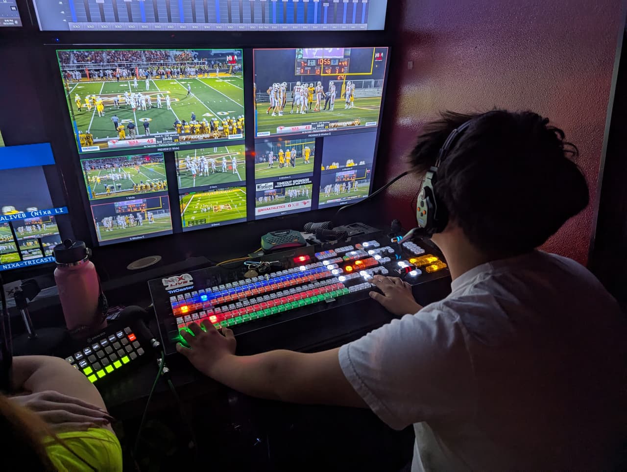 Students collaborating over production equipment during a live broadcast